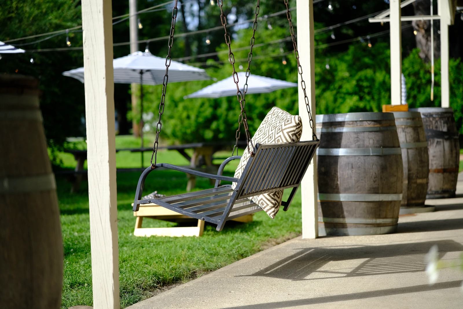 Porch swing by the wine barrels on the lawn